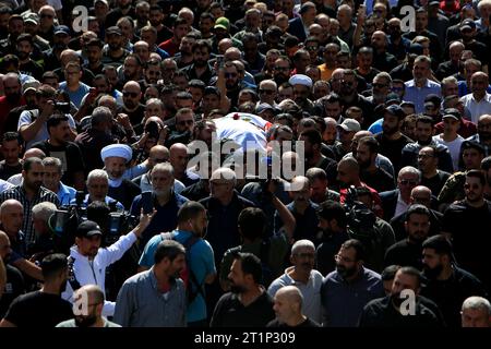 Beyrouth, ville libanaise de Khiam. 14 octobre 2023. Les gens pleurent le photojournaliste libanais Issam Abdallah, tué par un obus israélien, dans la ville libanaise de Khiam, le 14 octobre 2023. Issam Abdallah, un journaliste libanais travaillant pour Reuters, a été tué, et six autres journalistes d'agences internationales, dont l'Agence France-presse (AFP) et la chaîne de télévision Al-Jazeera, ont été blessés vendredi soir dans des attaques israéliennes contre le village d'Alma al-Shaab, au sud du Liban, a rapporté la chaîne de télévision libanaise MTV. Crédit : Ali Hashisho/Xinhua/Alamy Live News Banque D'Images