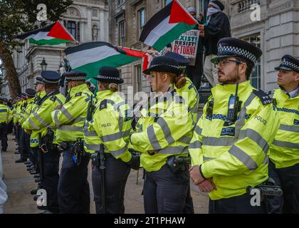 Des policiers de met montent la garde près de Downing Street pendant la marche pro Palestine à Londres. Banque D'Images