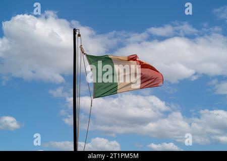 Un drapeau italien volant contre le ciel bleu Banque D'Images