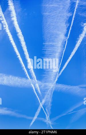 Des contrails de jet entrecroisés dans le ciel bleu - centre de la France. Banque D'Images