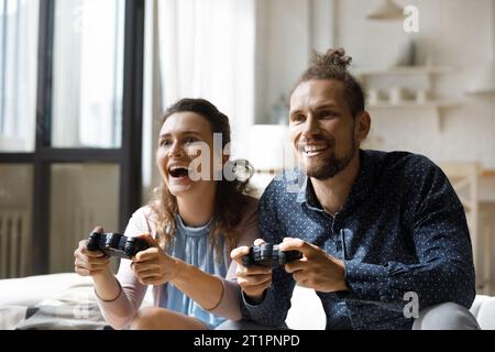 Joyeux couple excité jouant à des jeux vidéo virtuels Banque D'Images