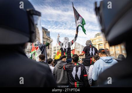 14 octobre 2023, Hesse, Francfort-sur-le-main : des policiers entourent les participants à une manifestation pro-palestinienne non autorisée brandissant des drapeaux palestiniens. Peu de temps après, les données personnelles des personnes impliquées ont été établies. Une interdiction de la ville de Francfort sur un rassemblement pro-palestinien initialement prévu s ' est dressée devant le tribunal, mais plusieurs centaines de personnes n ' ont pas respecté cette interdiction. Photo : Frank Rumpenhorst/dpa/Frank Rumpenhorst/dpa crédit : dpa Picture alliance/Alamy Live News Banque D'Images