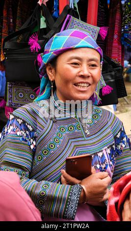 Scène du marché de CAN Cau, Vietnam. Femme Hmong tenant son téléphone portable. Province de Lao Cai. Banque D'Images
