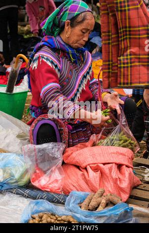 Scène du marché de CAN Cau, Vietnam. Femme Hmong mettant des haricots dans un sac. Province de Lao Cai. Banque D'Images