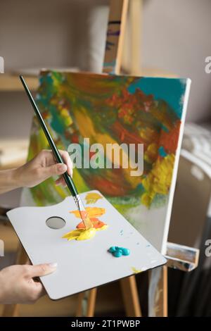 Femme peintre créer l'image, mélanger les couleurs, travailler en atelier Banque D'Images