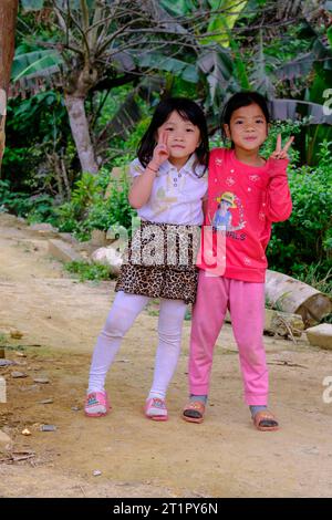 Bac Ha, Vietnam. Jeunes filles Hmong posant pour leur photo. Province de Lao Cai. Banque D'Images