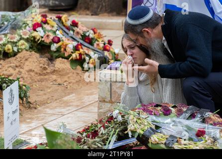 Jérusalem, Israël. 15 octobre 2023. Une jeune femme israélienne est réconfortée alors qu'elle pleure le 15 octobre 2023 sur la tombe du sergent Dvir Leesha enterré le 8 octobre 2023 dans le Mt. Cimetière militaire Herzl à Jérusalem. Les civils tués dans des attaques terroristes sont régulièrement enterrés en Israël dans des cimetières militaires. Il y a plus de 30 tombes fraîchement creusées qui détiennent des Israéliens tués par le groupe terroriste Hamas dans leurs attaques dans le sud d’Israël le 7 octobre 2023. Photo de Jim Hollander/UPI crédit : UPI/Alamy Live News Banque D'Images