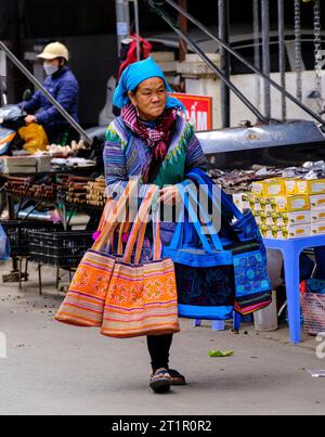 Bac Ha, Vietnam. Scène du marché du dimanche. Femme Hmong avec des sacs à vendre. Province de Lao Cai. Banque D'Images