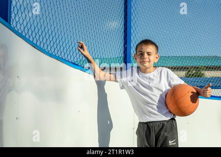 Courage in the Twilight : la résilience des garçons rayonne dans un match de basket-ball en plein air Banque D'Images