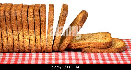 Gros plan d'une rangée d'un groupe de biscottes au-dessus d'une table avec une nappe à carreaux rouge et blanc, isolée sur fond blanc. Banque D'Images