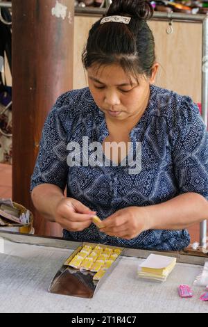 Fleuve Mékong, Vietnam. Femme enveloppant Candy dans Coconut Candy Factory. Banque D'Images