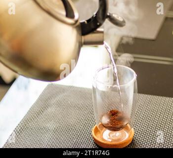 Jet d'eau chaude versé dans la tasse transparente pour préparer le café. Banque D'Images