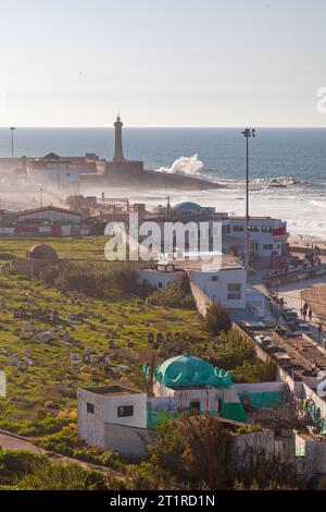 Cimetière Al Yabouri avec le phare de Rabat sur la plate-forme de Borj Sirat. Banque D'Images