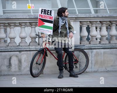 Des marcheurs pro-palestiniens avec une affiche de Free Palestine assis à vélo à Westminster Londres, au Royaume-Uni, lors de la manifestation de la campagne de solidarité de Palestine, défilent pour protester contre le consortium Israël Palestine sur la bande de Gaza Banque D'Images