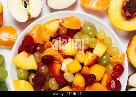 Salade de fruits avec fruits tranchés, raisins mélangés, framboises, nectarines, mandarines et pommes Banque D'Images