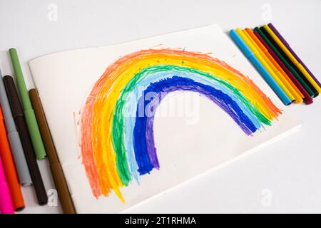 Dessin d'un enfant de 6 ans - un arc-en-ciel dessiné avec des stylos feutre dans un carnet de croquis Banque D'Images