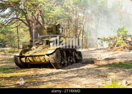 Un char léger américain Stuart de la Seconde Guerre mondiale. Tank dans le champ de bataille au milieu de la fumée et de la poussière. Banque D'Images