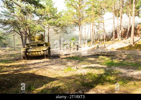 Un char léger américain Stuart de la Seconde Guerre mondiale. Tank dans le champ de bataille au milieu de la fumée et de la poussière Banque D'Images