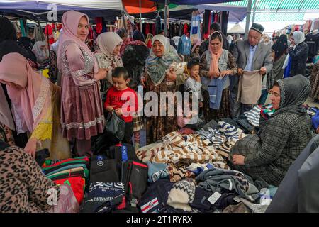 Namangan, Ouzbékistan - 15 octobre 2023 : des gens magasinent des vêtements au Chorsu Bazaar à Namangan, Ouzbékistan. Banque D'Images