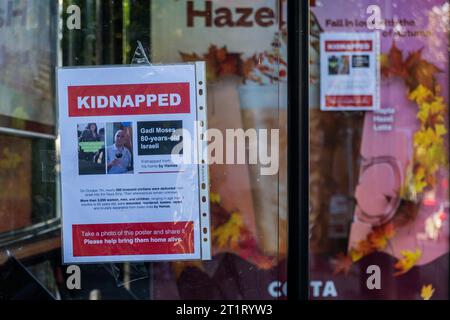 Londres, Royaume-Uni. 15 octobre 2023. Trois hommes et deux jeunes enfants ont mis en place des affiches kidnappées autour de Belsize Park, au nord de Londres. Ils demandent de l'aide pour les 200 civils innocents enlevés par le Hamas et emmenés dans la bande de Gaza. Crédit : Guy Bell/Alamy Live News Banque D'Images