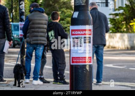 Londres, Royaume-Uni. 15 octobre 2023. Trois hommes et deux jeunes enfants ont mis en place des affiches kidnappées autour de Belsize Park, au nord de Londres. Ils demandent de l'aide pour les 200 civils innocents enlevés par le Hamas et emmenés dans la bande de Gaza. Crédit : Guy Bell/Alamy Live News Banque D'Images