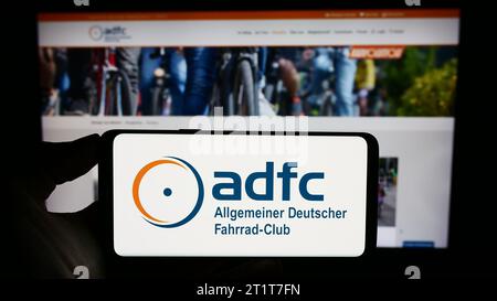 Personne détenant un téléphone cellulaire avec le logo de Allgemeiner Deutscher Fahrrad-Club e.V. (ADFC) devant la page Web. Concentrez-vous sur l'affichage du téléphone. Banque D'Images