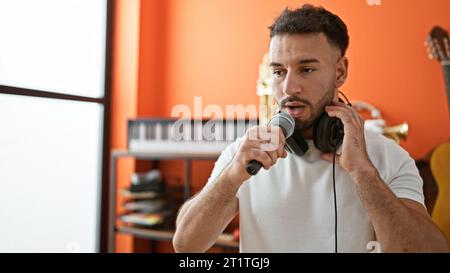 Jeune musicien arabe chantant une chanson au studio de musique Banque D'Images