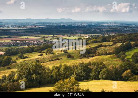 Vue sur le paysage des collines, des arbres, des champs et des broussailles du Gloucestershire avec les collines de Malvern vues au loin. Banque D'Images