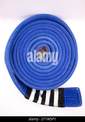 Une ceinture de jiu jitsu brésilien roulée de rang bleu avec quatre bandes Banque D'Images