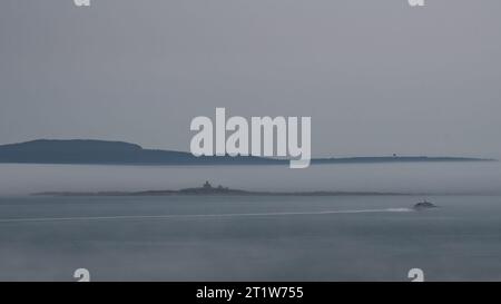 Phare d'Egg Rock de Park Loop Road dans le brouillard avec le bateau passant visible. Banque D'Images
