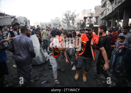 Rafah, Gaza. 15 octobre 2023. Des Palestiniens branchent un homme blessé suite à une frappe israélienne sur un immeuble à Rafah, dans le Sud de la bande de Gaza, dimanche 15 octobre 2023. Les Nations Unies ont signalé que plus de 400 000 2000 Palestiniens avaient déjà fui le nord de Gaza à la suite d ' un bombardement aérien israélien massif qui avait tué plus de 1 000 Palestiniens, dont la moitié étaient des enfants et des femmes. Photo par Ismael Mohamad/UPI crédit : UPI/Alamy Live News Banque D'Images