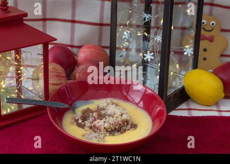 Grande portion de rhubarbe et crumble aux pommes avec crème anglaise chaude pour un pudding d'hiver copieux Banque D'Images
