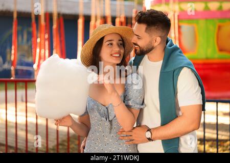 Heureux couple avec des bonbons de coton à funfair Banque D'Images