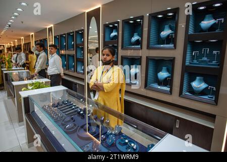 New Delhi, Inde. 15 octobre 2023. Un employé attend les clients, le jour du lancement du showroom Kalyan Jewelers nouvellement ouvert à Karol Bagh, New Delhi, Inde. Kalyan Jewelers est une chaîne indienne de showrooms de bijoux. Il a été fondé par T. S. Kalyanaraman en 1993. Crédit : SOPA Images Limited/Alamy Live News Banque D'Images