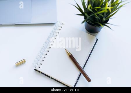 ouvrez le bloc-notes avec une feuille vierge pour les résolutions de la nouvelle année, les souhaits ou la liste des tâches à faire. Ordinateur portable et smartphone en arrière-plan Banque D'Images