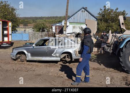 Les sapeurs ukrainiens regardent la voiture endommagée avec la lettre “Z” (symbole de la guerre de la Russie en Ukraine) lors de l'opération de déminage à Velyka Oleksandrivka. En mars 2022, Velyka Oleksandrivka est occupée par les forces russes. Le 4 octobre 2022, les autorités ukrainiennes ont repris le contrôle de la colonie pendant la contre-offensive sud. Kyiv nord, Sumy, Tchernihiv, Mykolaïv sud, Zaporizhzhia, Kherson et les régions orientales de Kharkiv, Louhansk et Donetsk sont les plus minées, selon le Service d'urgence de l'Ukraine. Il faut au moins dix ans pour nettoyer ces zones. (Photo de et Banque D'Images