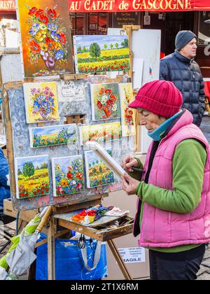 Peintre et exposition des œuvres de l'artiste de peintures colorées de fleurs à vendre, place du Tertre, Montmartre, 18e arrondissement, Paris, France Banque D'Images