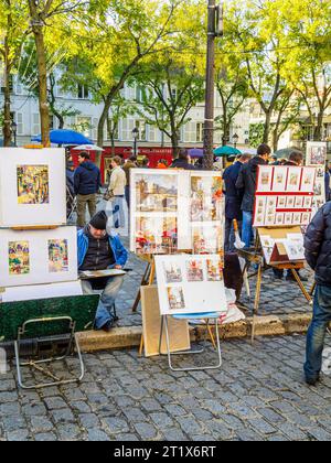 Artistes au travail peignant et exposant des images à vendre place du Tertre, Montmartre, 18e arrondissement, Paris, France Banque D'Images