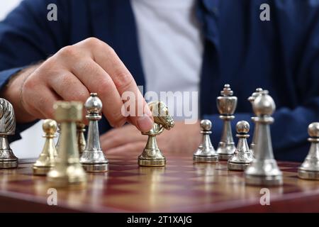 Homme déplaçant chevalier sur l'échiquier, vue rapprochée Banque D'Images