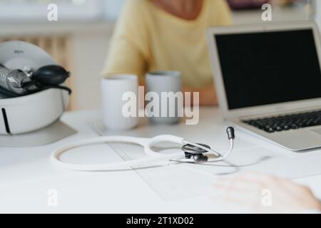 Gros plan du stéthoscope sur la table. Médecin discutant avec le patient. Gros plan, prise de vue partielle. Banque D'Images