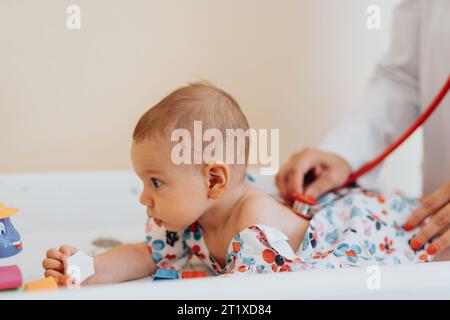 Un spécialiste en pédiatrie examine un bébé malade. Médecin vérifiant bébé à l'aide du stéthoscope, fournissant les soins de santé nécessaires. Banque D'Images