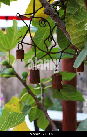 Silhouette de petites cloches métalliques patinées dans un patio de jardin de restaurant. Les cloches apportent une belle touche décorative dans la conception du jardin, Monterey Banque D'Images