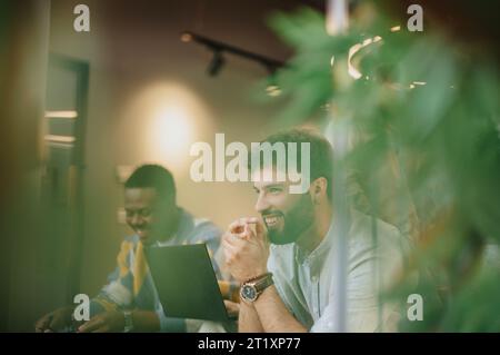 Professionnels multiraciaux discutant de l'analyse du marché dans l'espace de travail moderne du centre-ville Banque D'Images