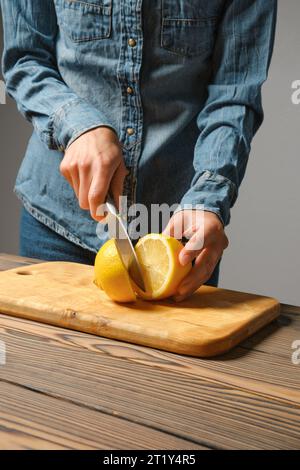 Vue rapprochée des mains féminines coupant le citron pour la sauce Banque D'Images
