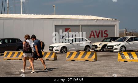 Herklion, Crète, Grèce, Europe. 26.09.2023. Touristes passant devant une location de voiture et des locaux de location sur le port de Herklion, Crète, Grèce. Banque D'Images