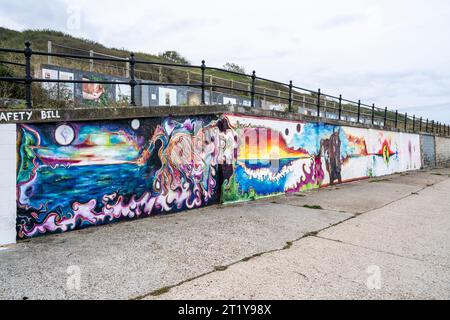 Série de peintures murales connectées sur une digue à Herne Bay dans le Kent. Peintes par un artiste inconnu de votre femme, les images, à l'exception d'une, sont reliées par un horizon, et représentent un dragon et un étalon noir. Banque D'Images
