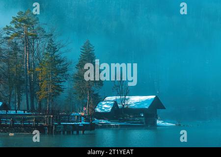 Bohinj Lake Boathhouse au bord de l'eau dans le matin brumeux d'hiver avec cabanes en bois et jetées, focalisation sélective Banque D'Images