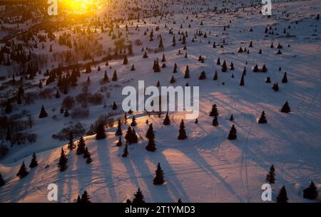 Sol recouvert de neige vu des airs près de Prince William Sound, Alaska au coucher du soleil. Banque D'Images