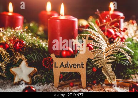 16 octobre 2023 : couronne de l'Avent avec des bougies allumées à Noël avec un signe en forme de renne avec texte : 1st Advent First Avent. Avent concept PHOTO MONTAGE *** Adventskranz mit brennenden Kerzen zu Weihnachten mit einem Schild in rentier Form mit Text : 1. Advent Erster Advent. Adventszeit Konzept FOTOMONTAGE Banque D'Images