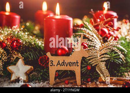 16 octobre 2023 : couronne de l'Avent avec des bougies allumées à Noël avec un signe en forme de renne avec texte : 3rd Avent Third Avent. Avent concept PHOTO MONTAGE *** Adventskranz mit brennenden Kerzen zu Weihnachten mit einem Schild in rentier Form mit Text : 3. Advent Dritter Advent. Adventszeit Konzept FOTOMONTAGE Banque D'Images